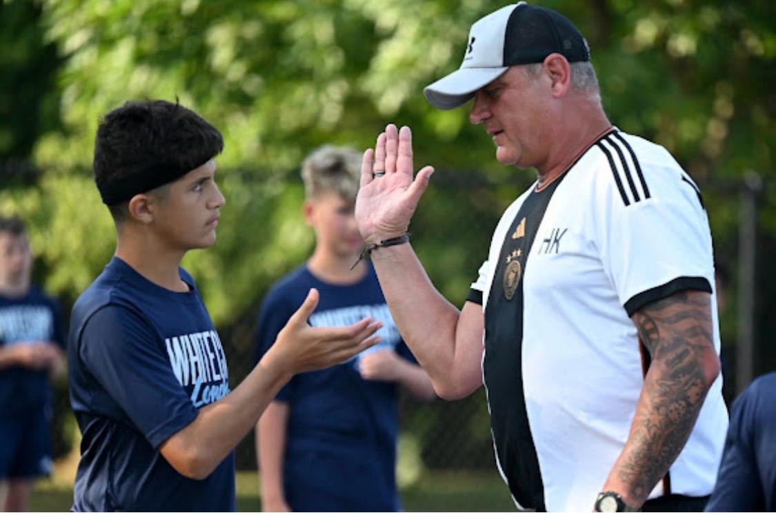 Coach and player acknowledging progress