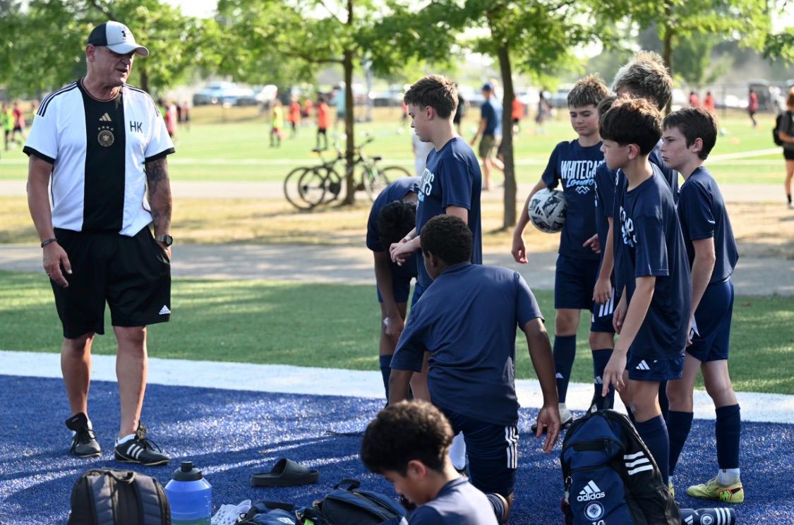 Holger Kraft speaking with youth players during a field session